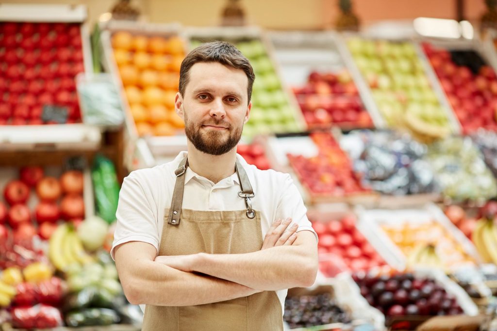 male-farmer-posing-at-market-stand-8USQ85R.jpg